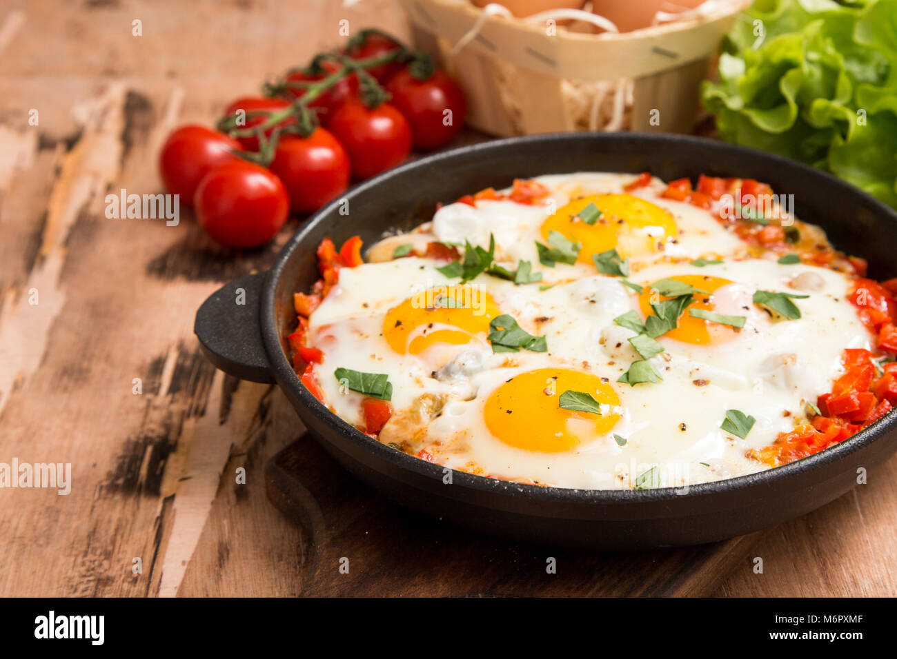 Shakshuka sains et savoureux dans une poêle. Oeufs au plat avec tomates, poivrons, légumes et fines herbes. Plat traditionnel du Moyen-Orient Banque D'Images