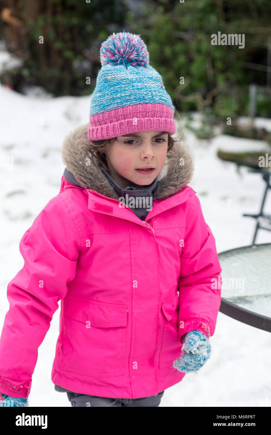 Cute little girl jouer à l'extérieur dans la neige en hiver. Portrait vertical demi-longueur Banque D'Images