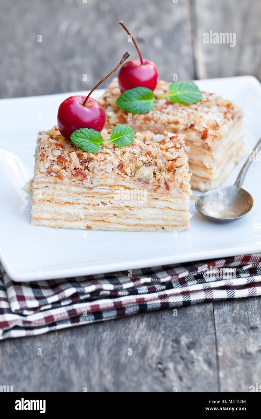 Napoléon gâteau avec les pommes sauvages et de menthe sur plaque carrée Banque D'Images