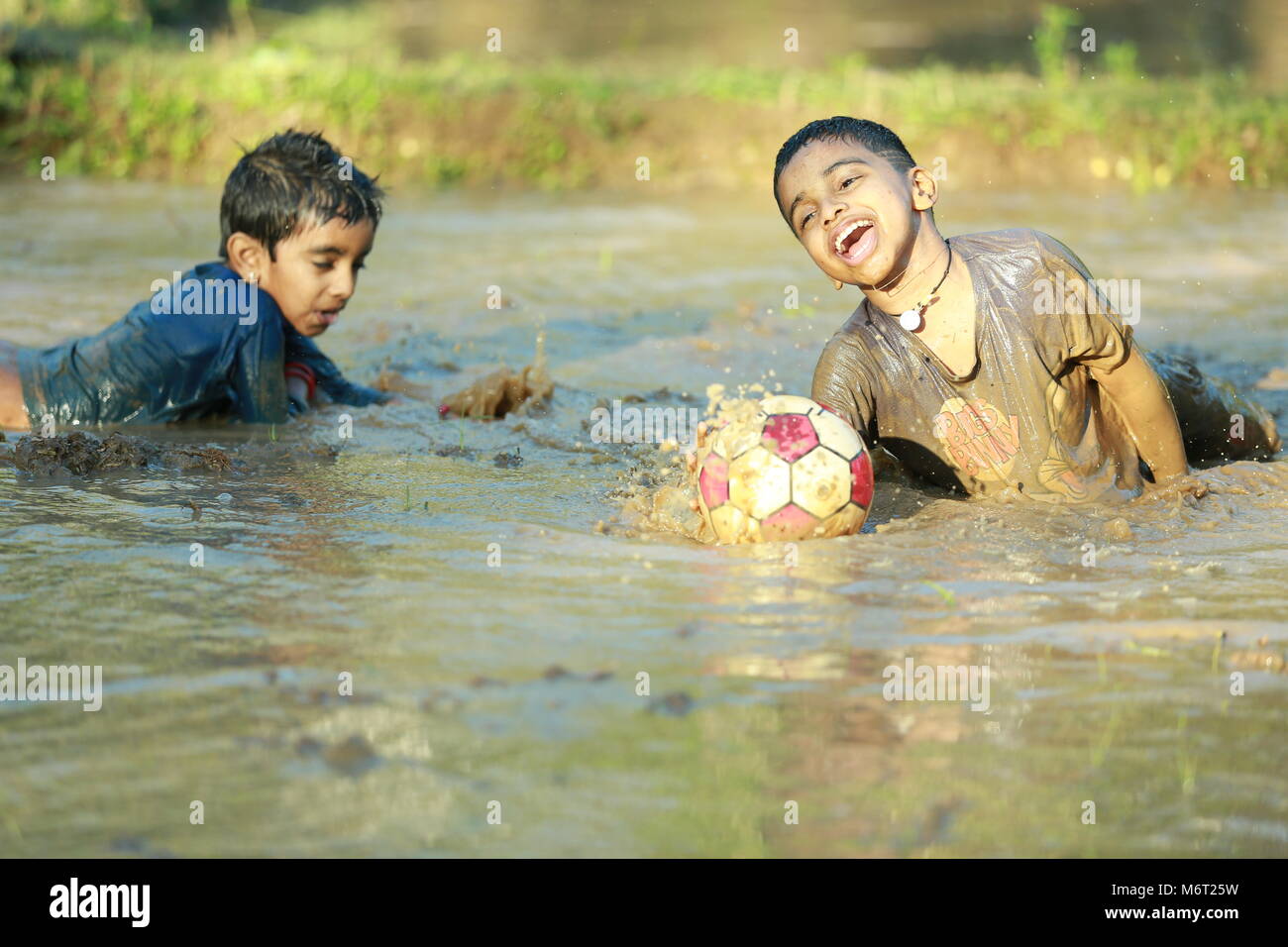 Enfance heureuse, de boue, jouer, Football, avoir du plaisir avec la nature, profiter de leur enfance, les enfants football,souvenirs, s'amusant, pour les enfants, cycle arbre avec boy, game Banque D'Images