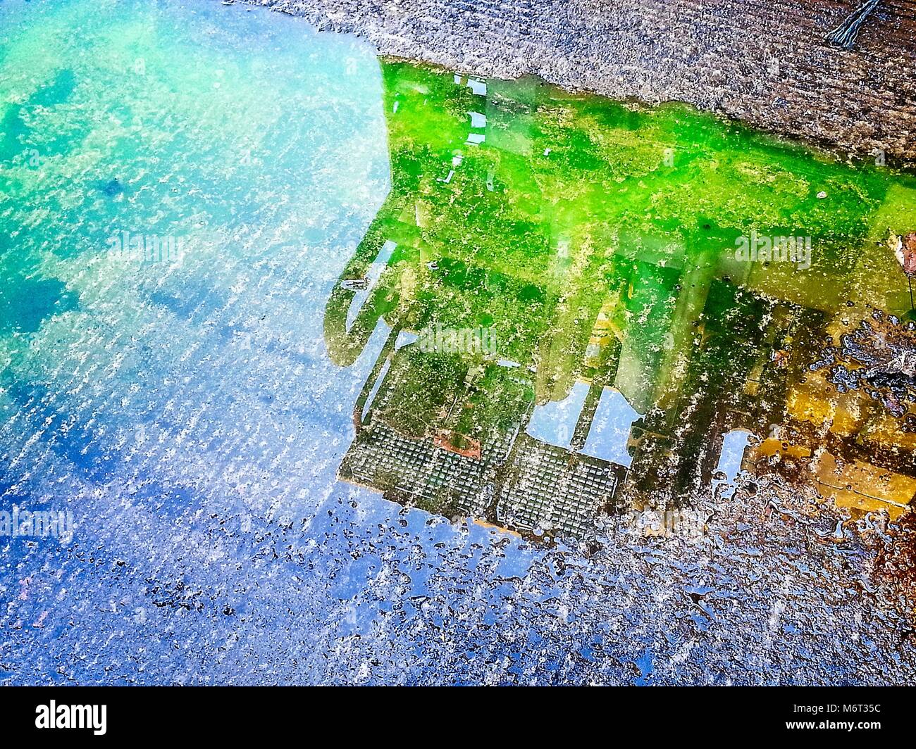 Matériel pour l'industrie pétrolière et gazière reflète dans la flaque. Couleurs très lumineux Banque D'Images