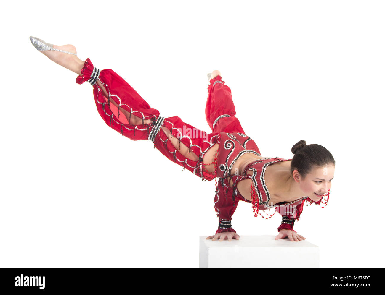 Exercices de gymnastique Acrobat n , l'image isolé sur un fond blanc. Jeune femme athlétique dans un justaucorps rouge, la pratique de l'acrobatie. Banque D'Images