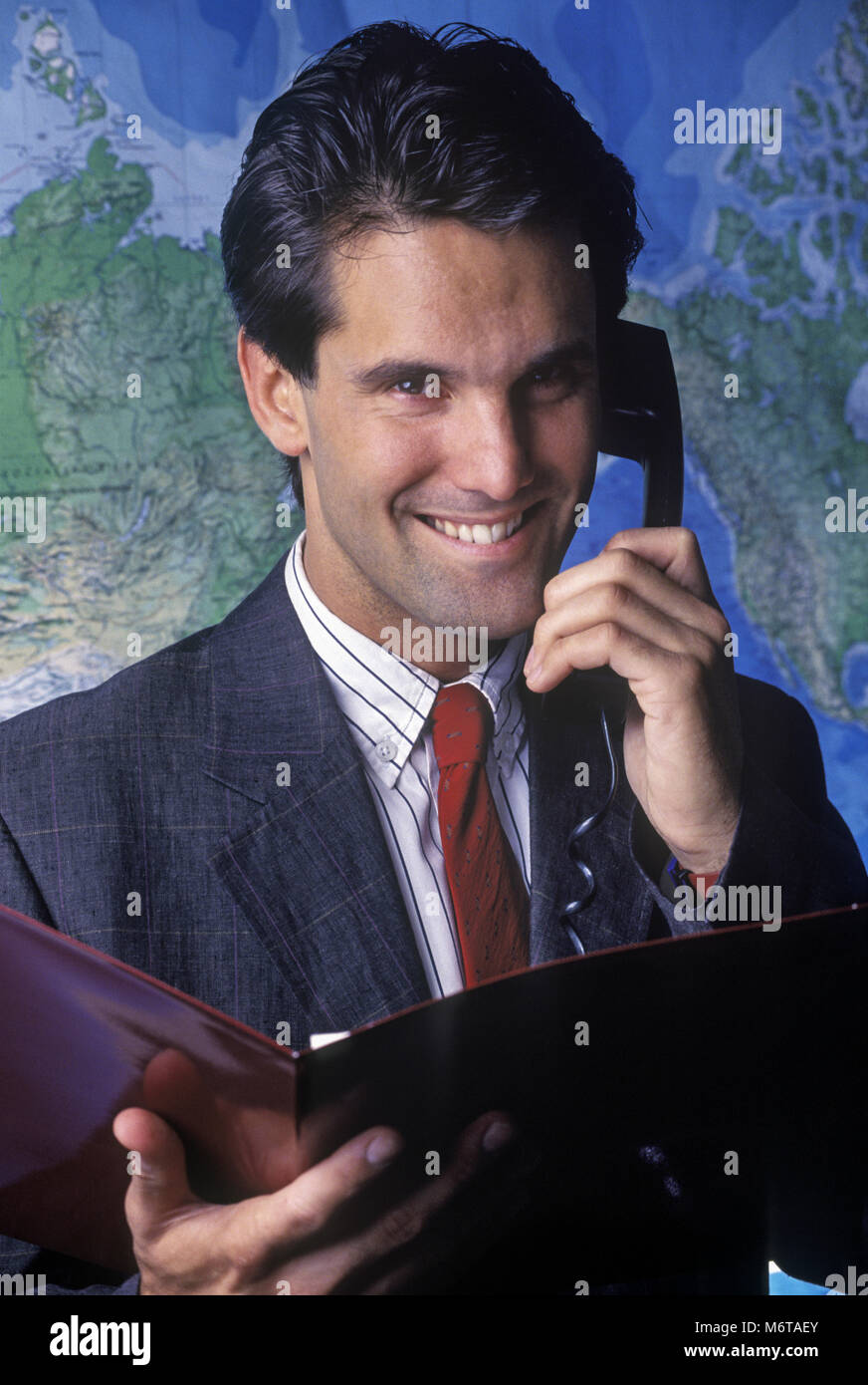 Historique 1990 CAUCASIAN BUSINESS MAN AVEC TÉLÉPHONE ET CARTE DU MONDE DE L'ère soviétique (©RAND MCNALLY, 1985) Banque D'Images