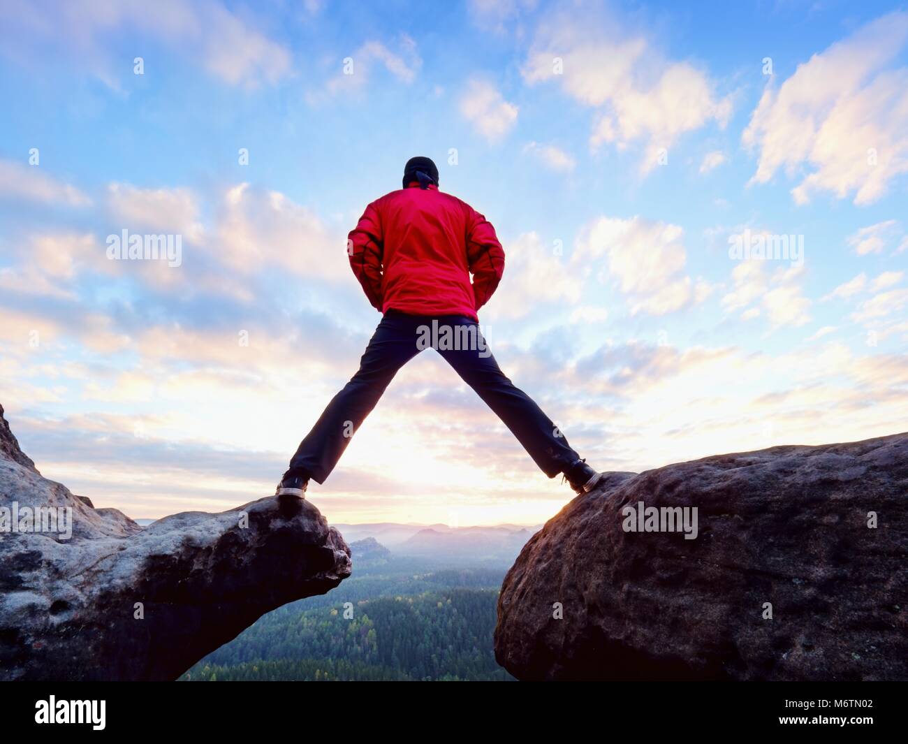 Man de la montagne. Homme de sauter d'une falaise sans corde. Moment risqué. Rough terrain rocheux. Banque D'Images