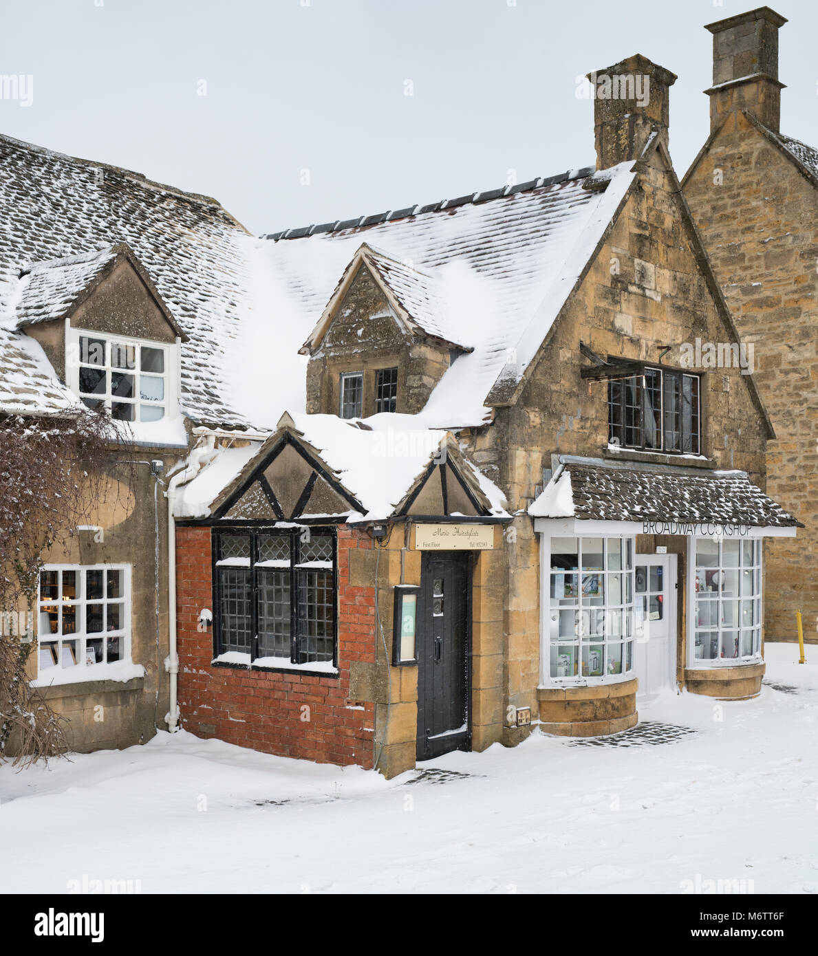 Boutiques de broadway dans la neige d'hiver. Broadway, Cotswolds, Worcestershire, Angleterre Banque D'Images