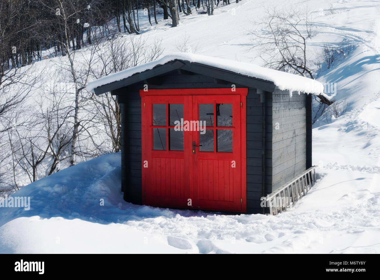 Cabane rouge vif sur la montagne couverte de neige en hiver Banque D'Images