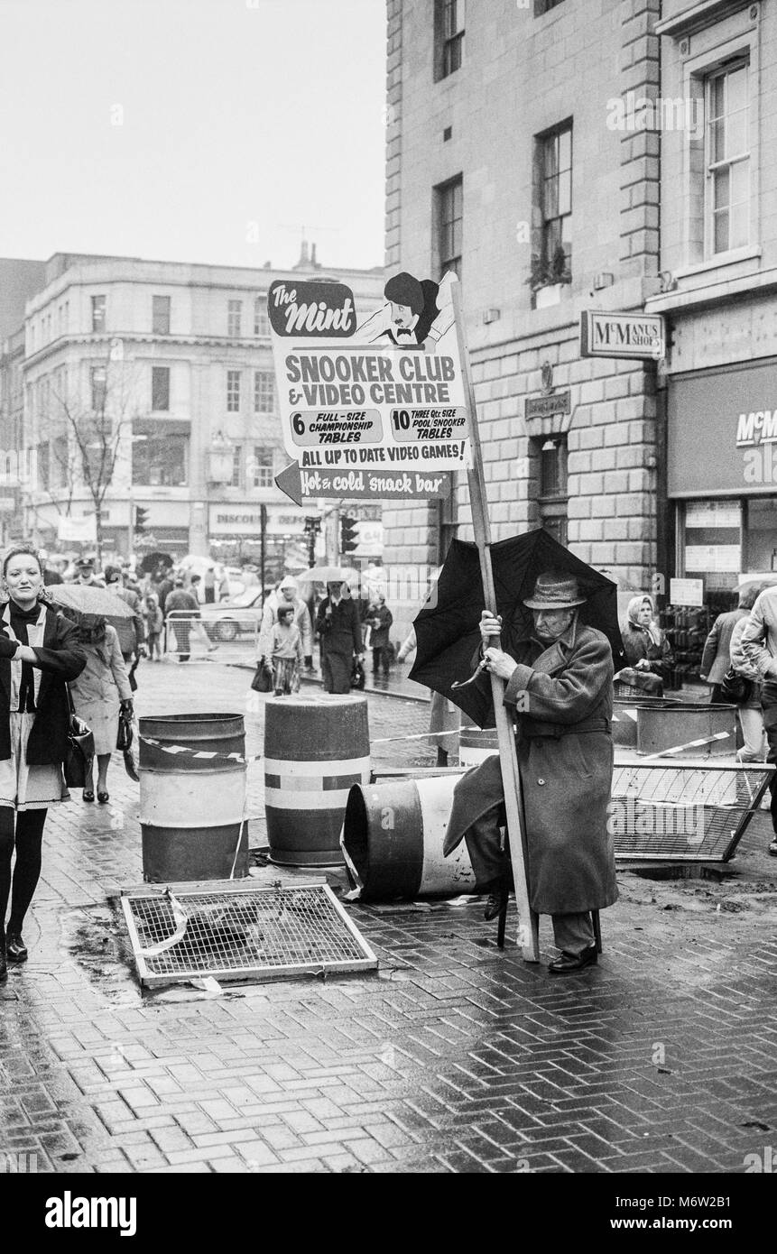 Henry Street, Dublin, Man holding sign advertising snooker club sous la pluie, des archives de 1988 photographie, Irlande Banque D'Images