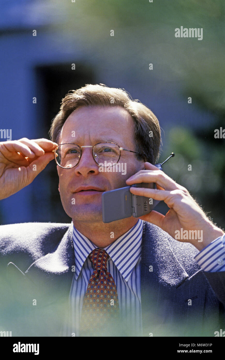 Historique 1995 CAUCASIAN BUSINESS MAN WITH MOBILE TÉLÉPHONE CELLULAIRE MOTOROLA CORP (©1995) à l'extérieur Banque D'Images