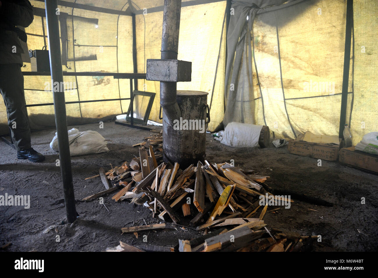 Pile de bois de chauffage et d'un réchaud "burzhuika" défini pour le chauffage tente de toile militaire. Le 1 février 2018. Gamme militaire dans Novo-Petrivtsi, Ukraine Banque D'Images