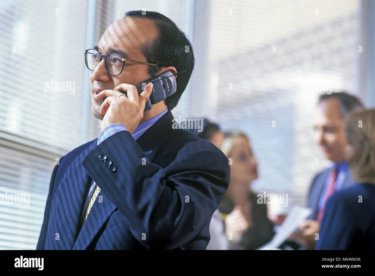 Historique 1998 L'HOMME D'AFFAIRES ASIATIQUE SÉANCE DANS LA SALLE DE CONFÉRENCE TÉLÉPHONE CELLULAIRE MOBILE HOLDING Banque D'Images