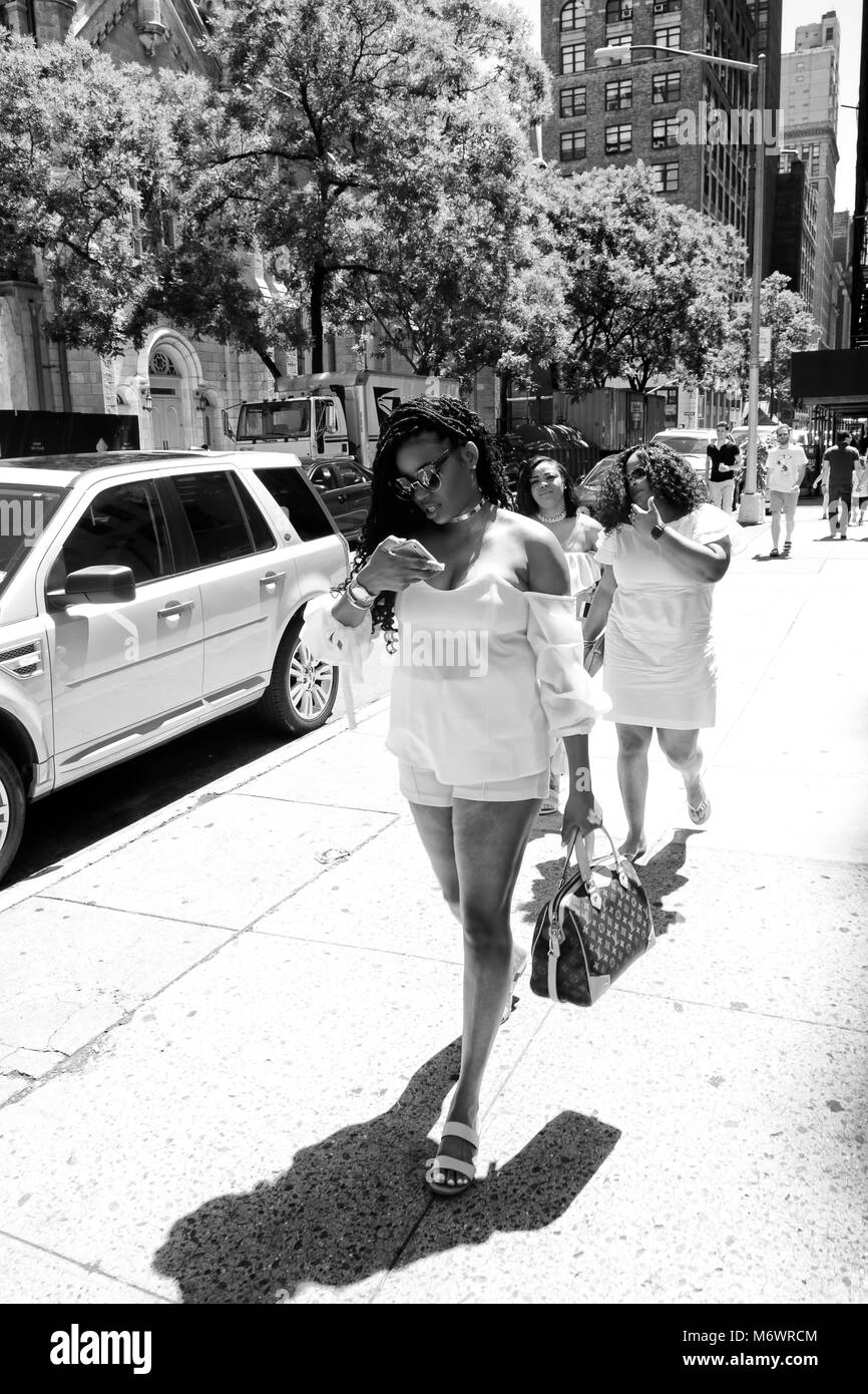 Belle femme noire à la mode robe blanche balade à Manhattan Banque D'Images