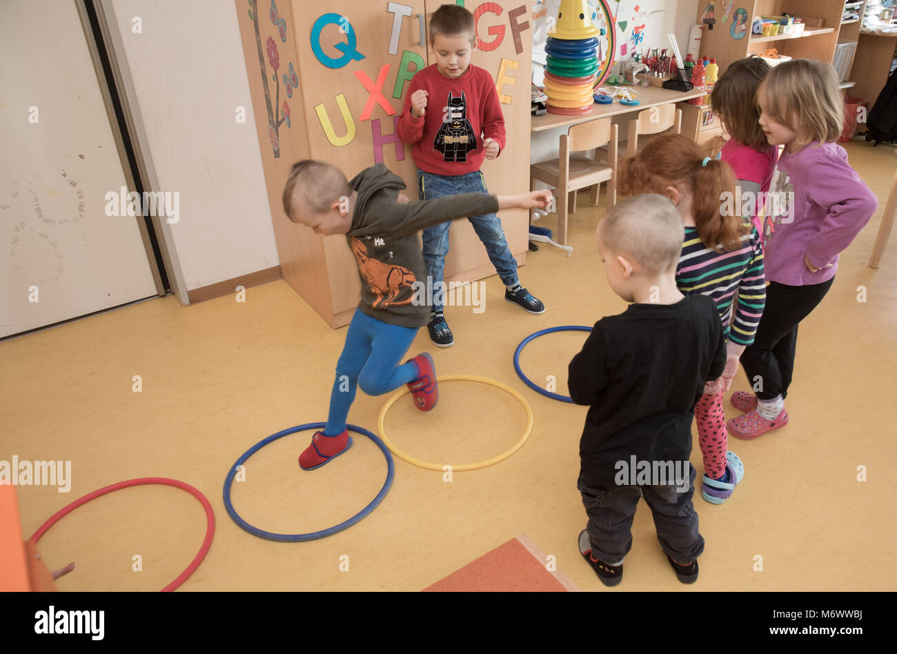 02 février 2018, Allemagne, Berlin : les enfants à l 'Galileo' pépinière sauter à travers quatre anneaux. Chaque cercle représente un pas de lave-linge. Les enfants sont ainsi sensibilisés à la technologie numérique à l'aide d'instructions supplémentaires. La fondation "Maison des petits chercheurs" est financé par le gouvernement fédéral et offre des cours de formation pour les enseignants,. Photo : Jörg Carstensen/dpa Banque D'Images