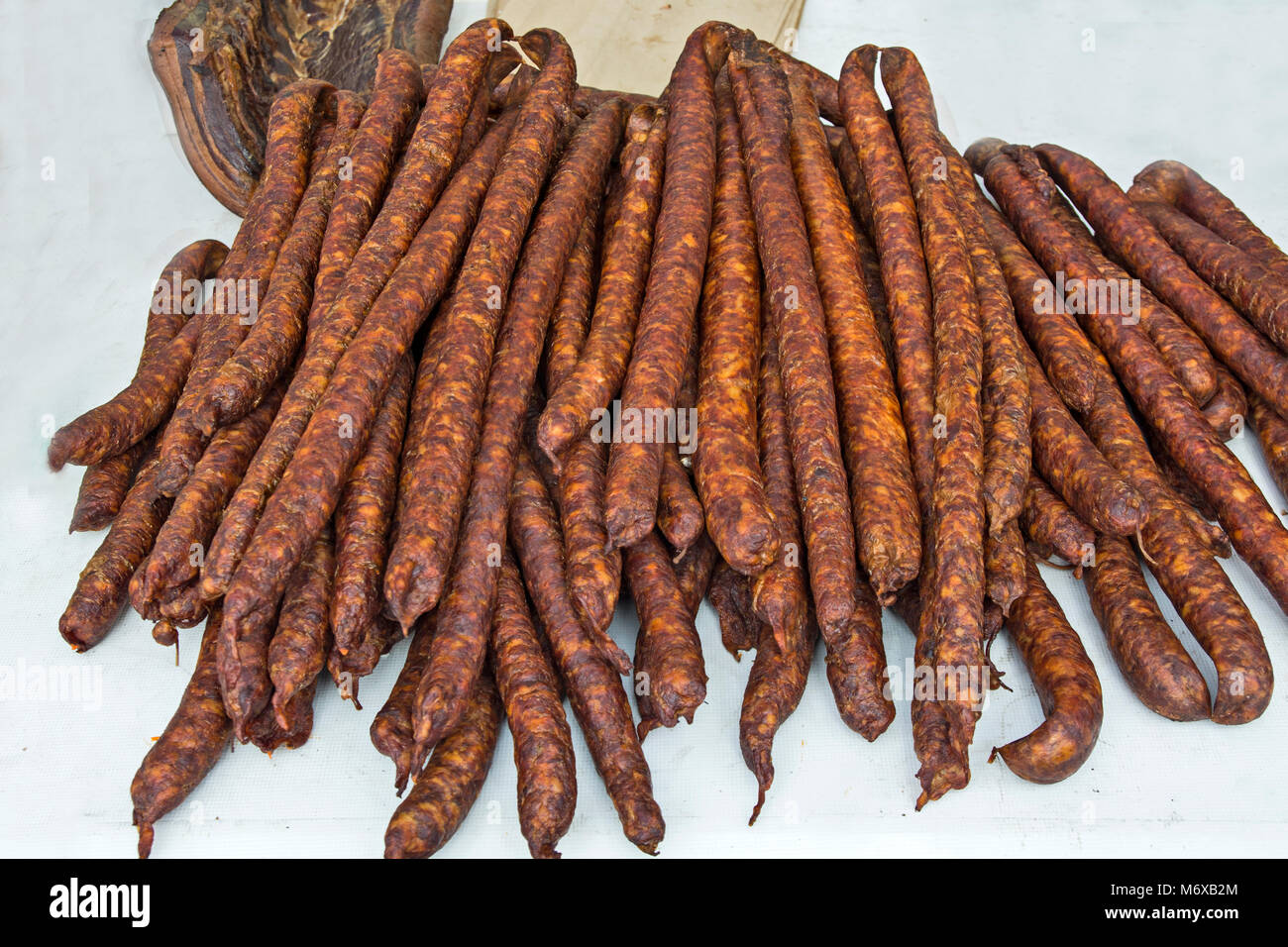 Des saucisses de porc fumé et séché debout sur la table pour la vente. Banque D'Images Des saucisses de porc fumé et séché debout sur la table pour la vente. Banque D'Images