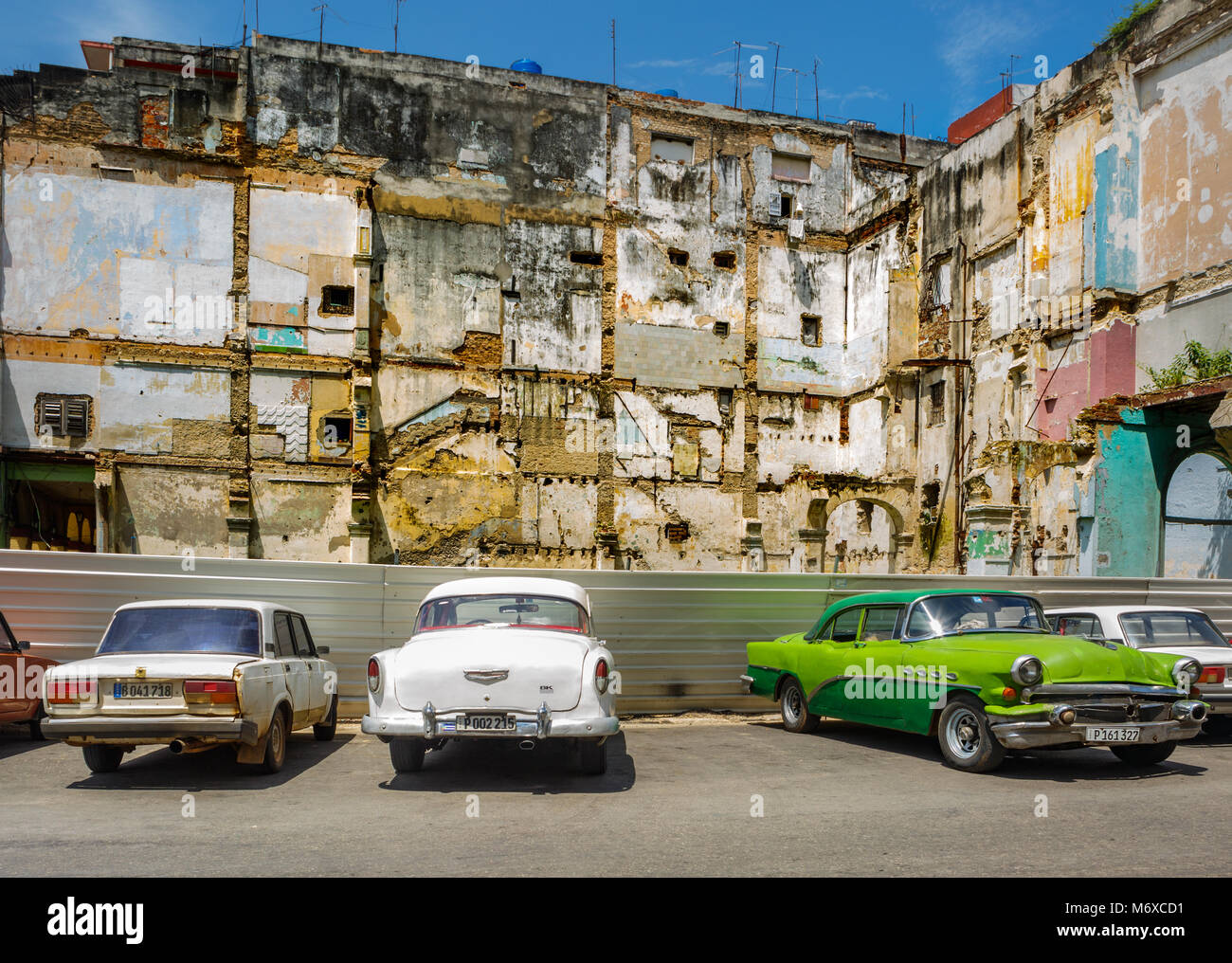 Vieilles voitures garées en face de l'immeuble délabré dans la vieille Havane Cuba Banque D'Images