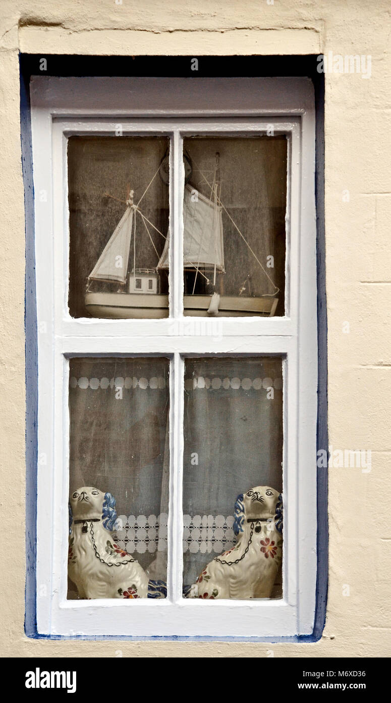 Les chiens staffordshire d'ornement et d'un navire à voile à décorer la fenêtre d'une maison à Cellardyke, Fife, Scotland Banque D'Images