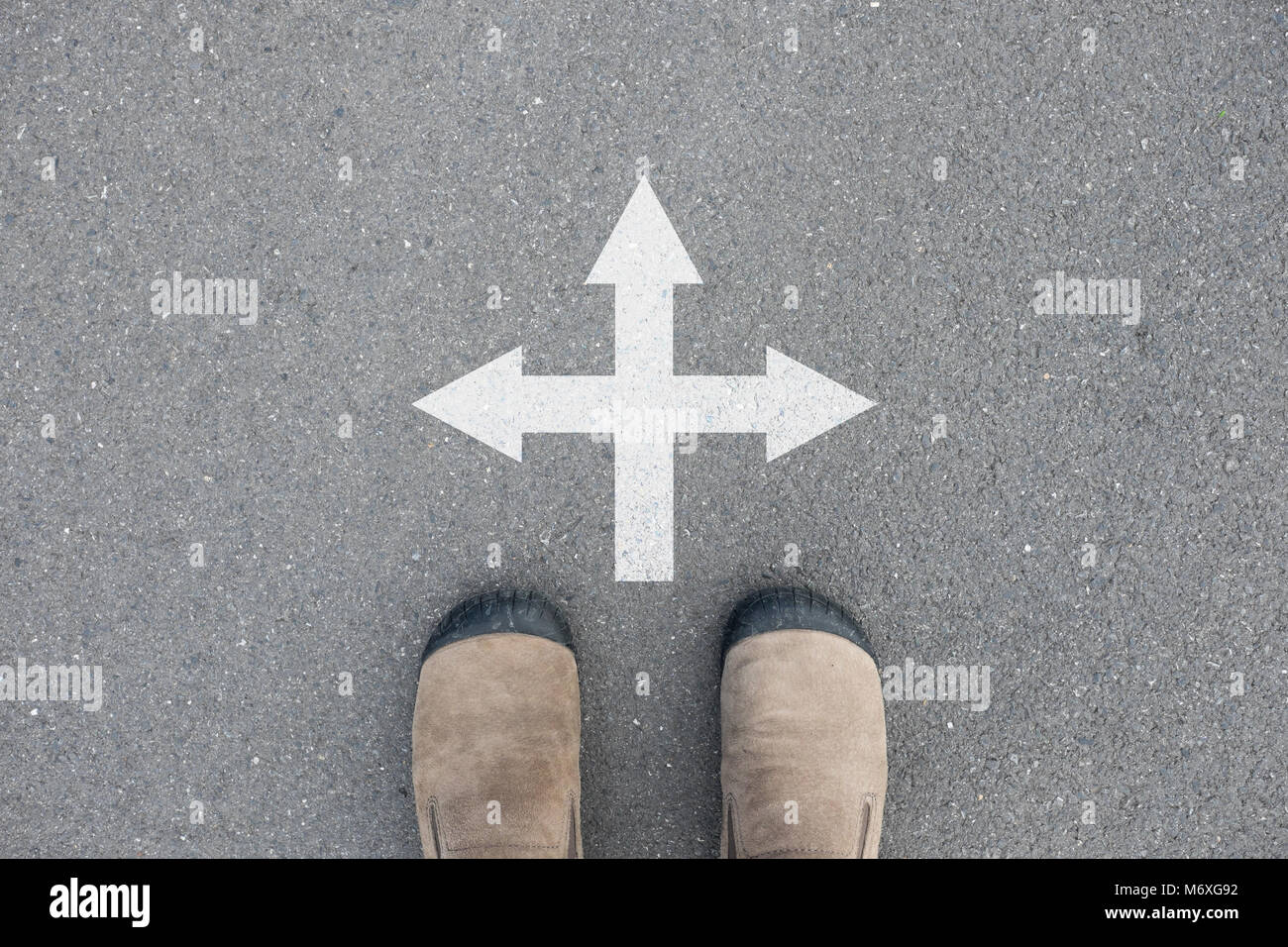 Brown Suede debout sur la route de béton bitumineux au carrefour et a décidé de faire - trois façons de choisir Banque D'Images