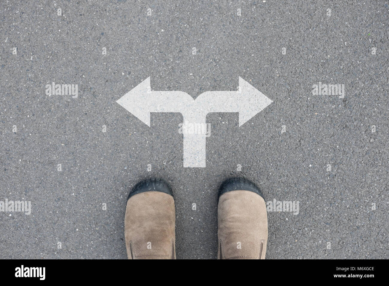 Chaussures en daim marron debout sur le plancher de béton d'asphalte au carrefour Banque D'Images