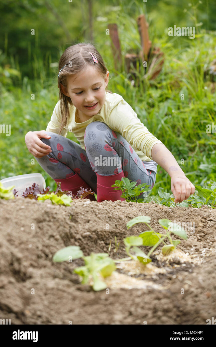 Petite fille s'amuser dans le jardin, plantation, jardinage, aider sa mère. Heureux, l'enfance naturelle concept. Banque D'Images