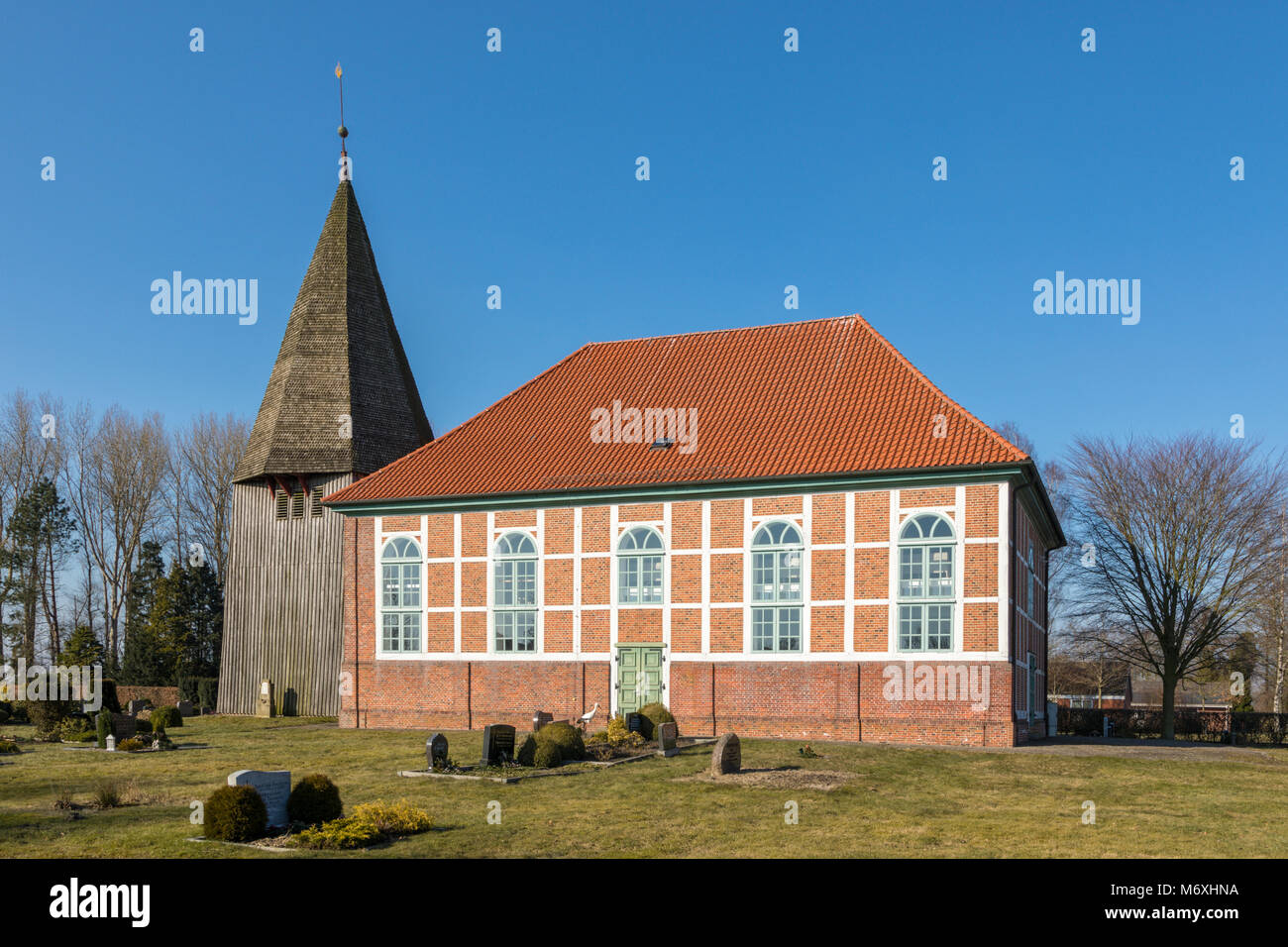 Église du 19ème siècle et le cimetière à Bonaduz, village Land Hadeln, Basse-Saxe, Allemagne. Cigogne blanche européenne au porte de l'église. Banque D'Images