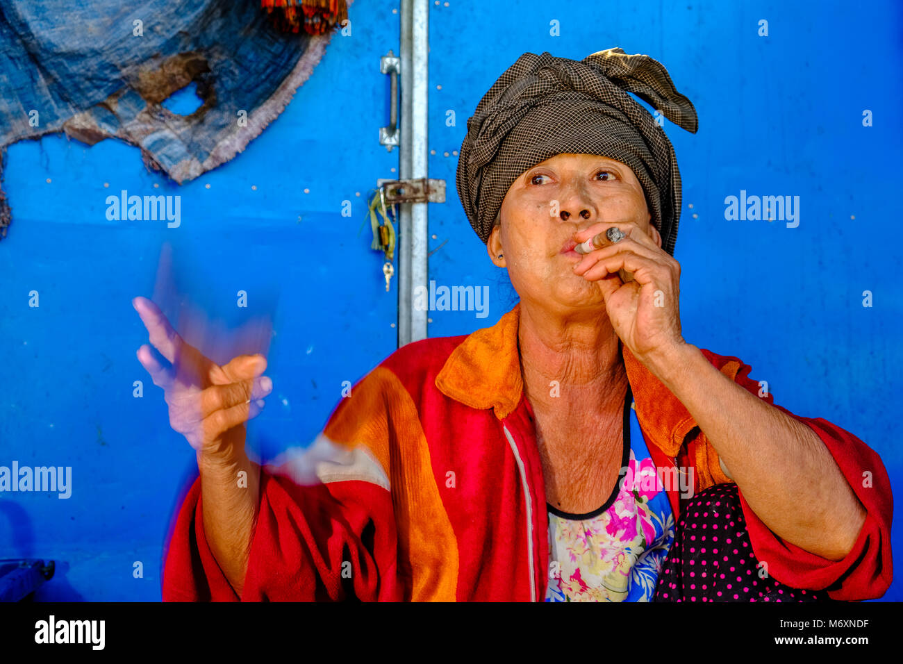 Les agriculteurs locaux une femme est fumer un Cheerot, un cigare, dans le marché de la rue de la ville Banque D'Images