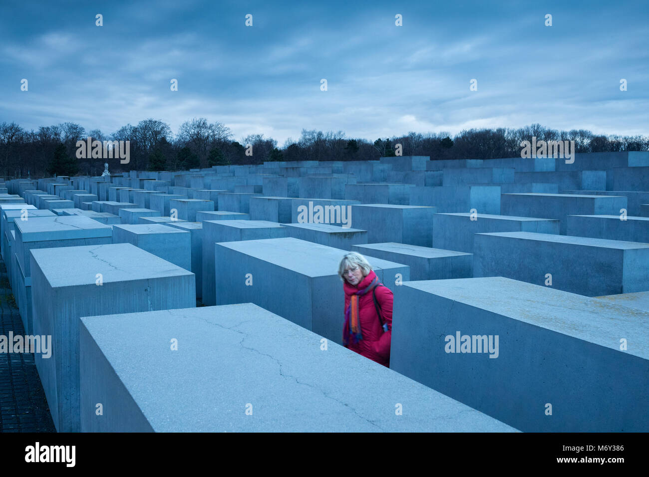 Une dame en rouge dans entre le mémorial de l'Holocauste, Mitte, Berlin, Allemagne Banque D'Images