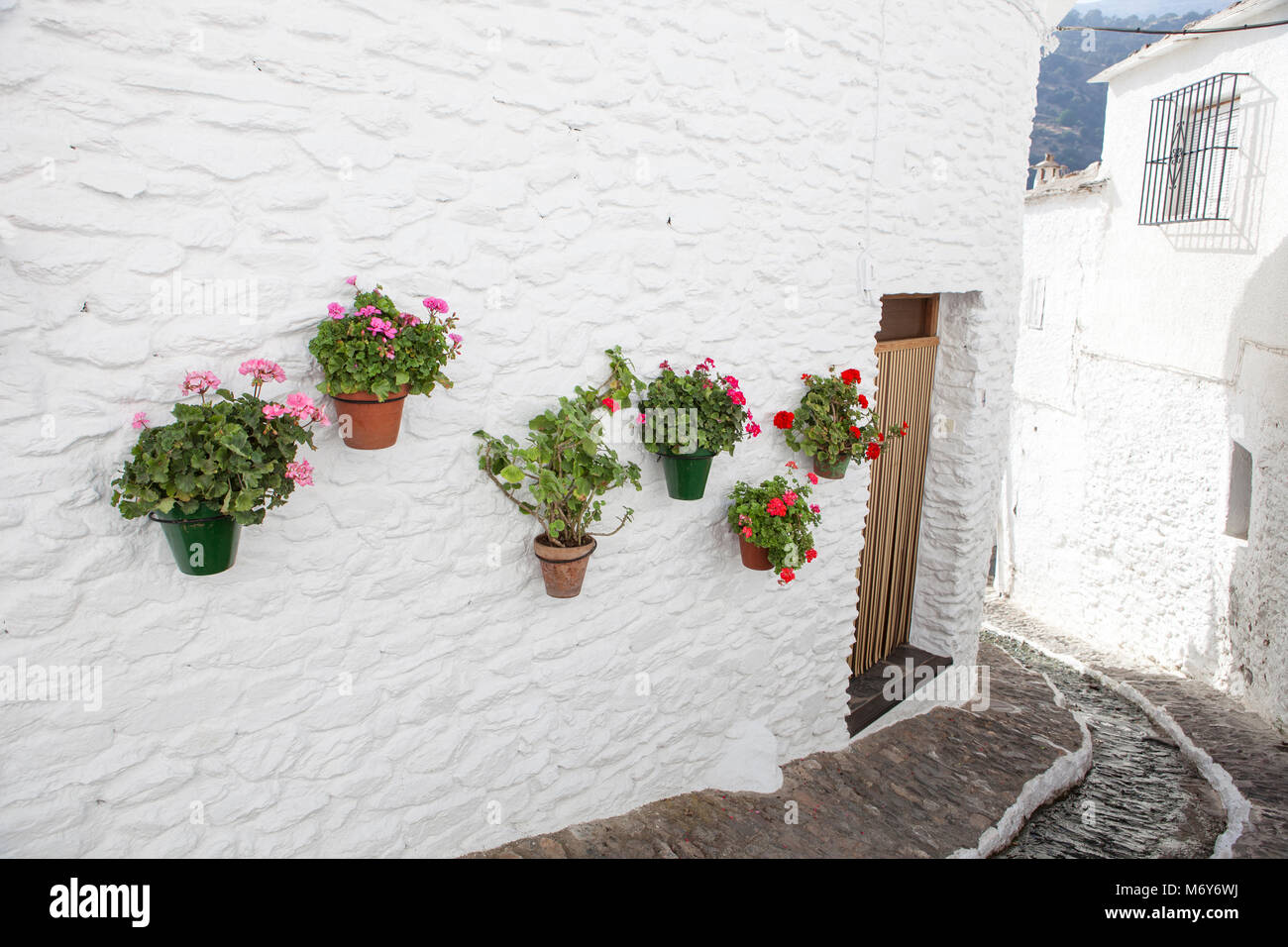 Belle rue tranquille avec de l'eau et de pots de canal dans le mur, Alpujarras, Granada, Espagne Banque D'Images