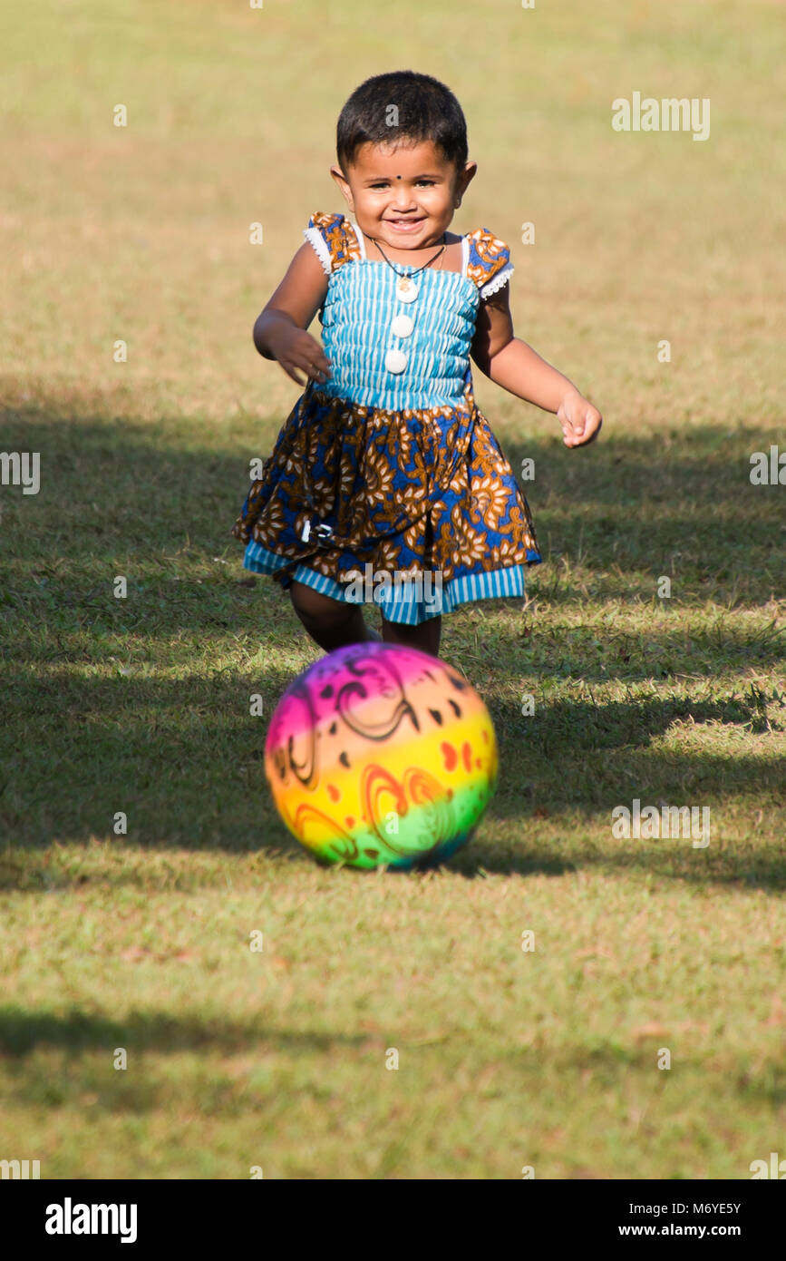 Portrait vertical d'une petite fille d'un coup en football Viharamahadevi Park, anciennement connu sous le nom de Victoria Park à Colombo, Sri Lanka. Banque D'Images