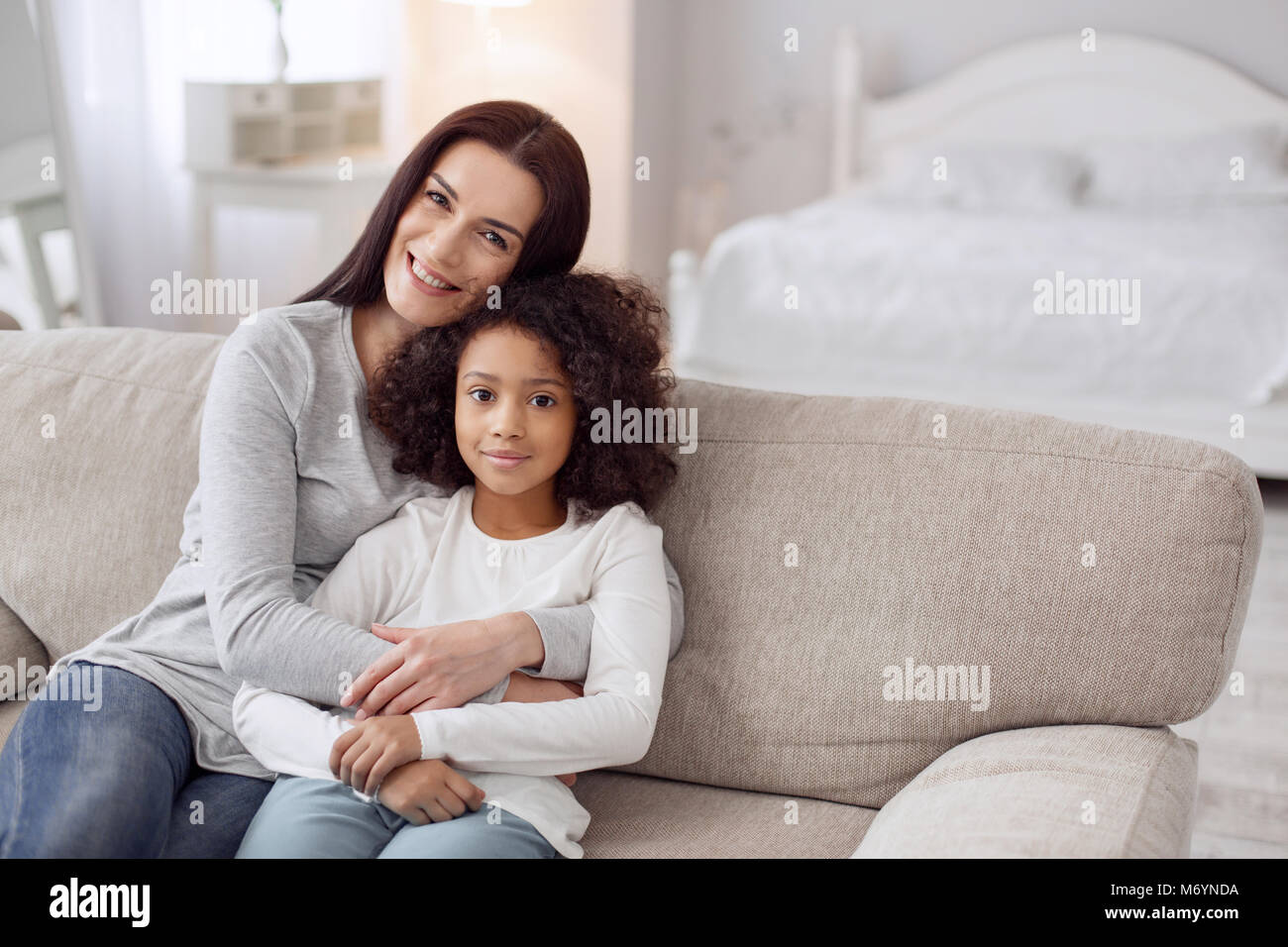 Mère et fille inspirée de l'emplacement sur le canapé Banque D'Images