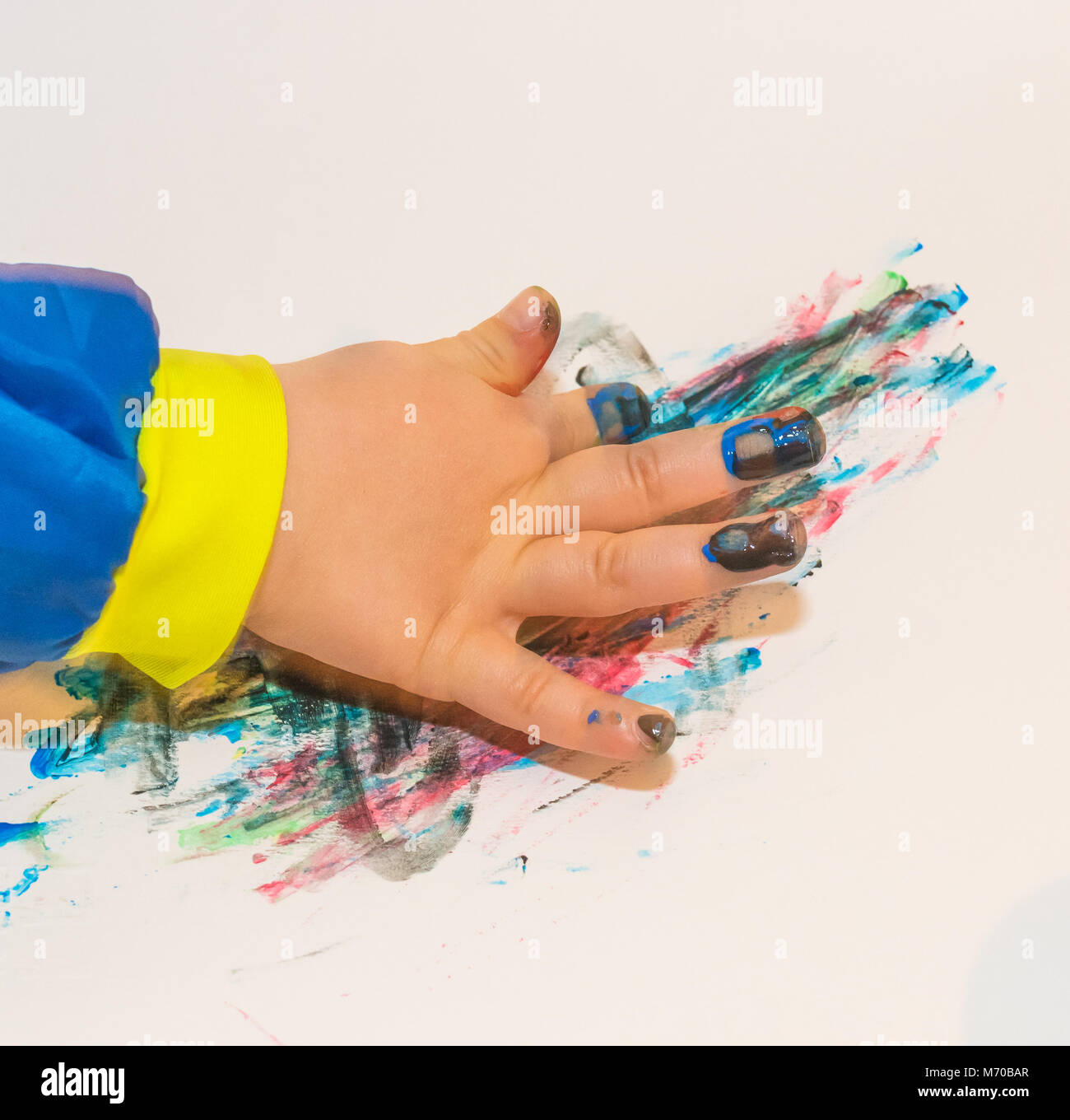 La main de l'enfant peint en couleurs paits. L'éducation, l'école, la créativité et la peinture concept. Un flou flou Banque D'Images