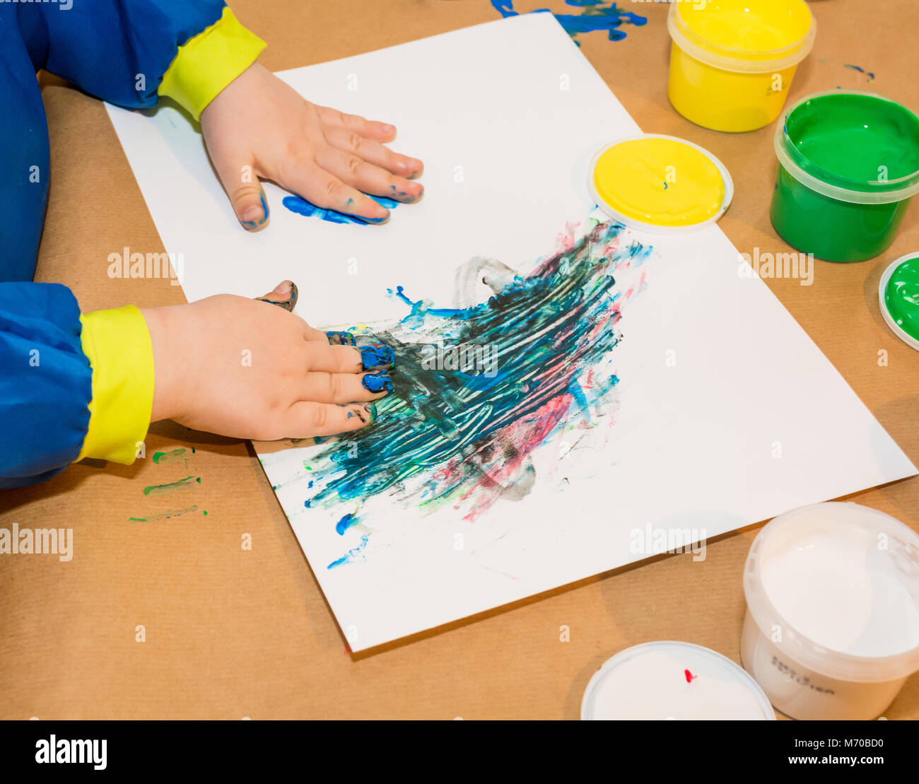 Les mains de l'enfant peint dans les peintures colorées. L'éducation, l'école, la créativité et la peinture concept. Un flou flou Banque D'Images