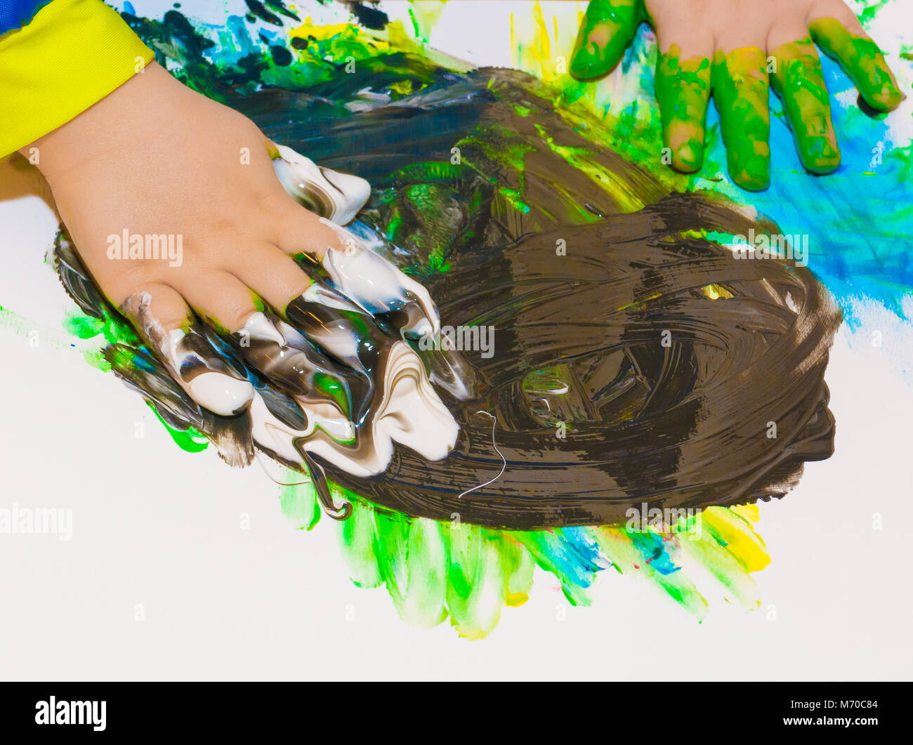 Les mains de l'enfant peint dans les peintures colorées. L'éducation, l'école, la créativité et la peinture concept. Un flou flou Banque D'Images