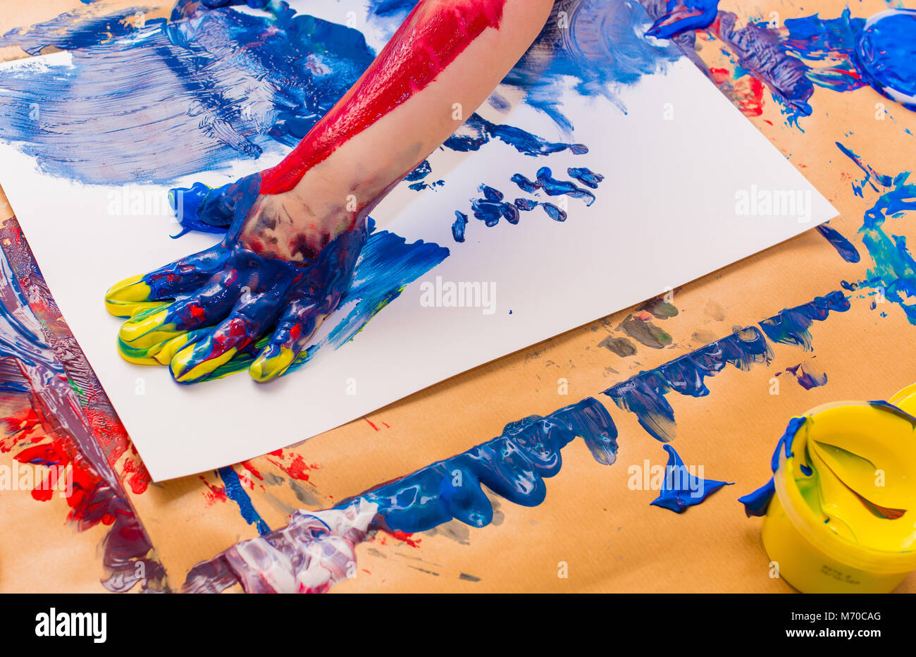 Peint à la main de l'enfant dans les peintures colorées. L'éducation, l'école, la créativité et la peinture concept. Un flou flou Banque D'Images