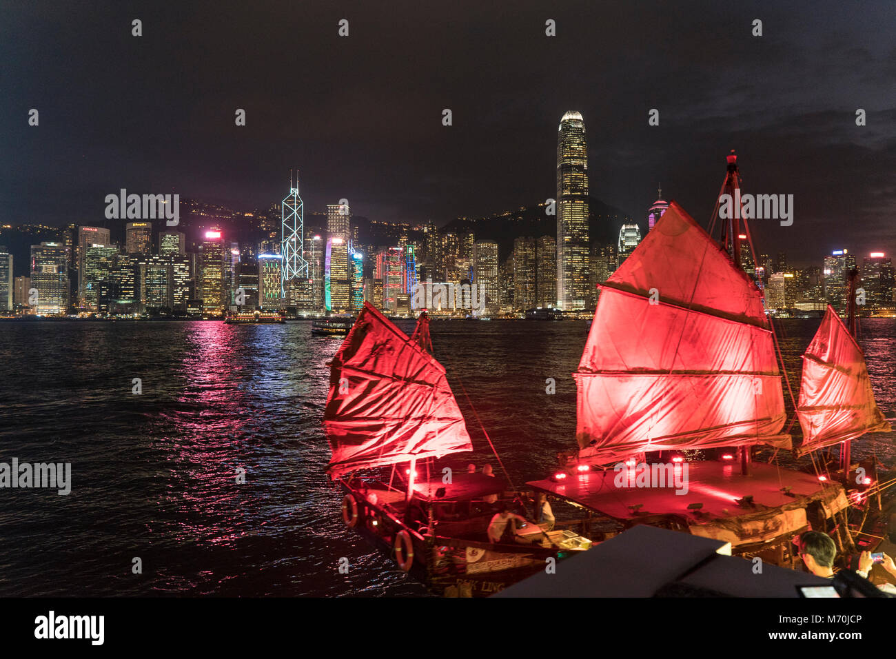 Hong Kong skyline at night de Victoria Harbour avec jonque traditionnelle en premier plan. Banque D'Images