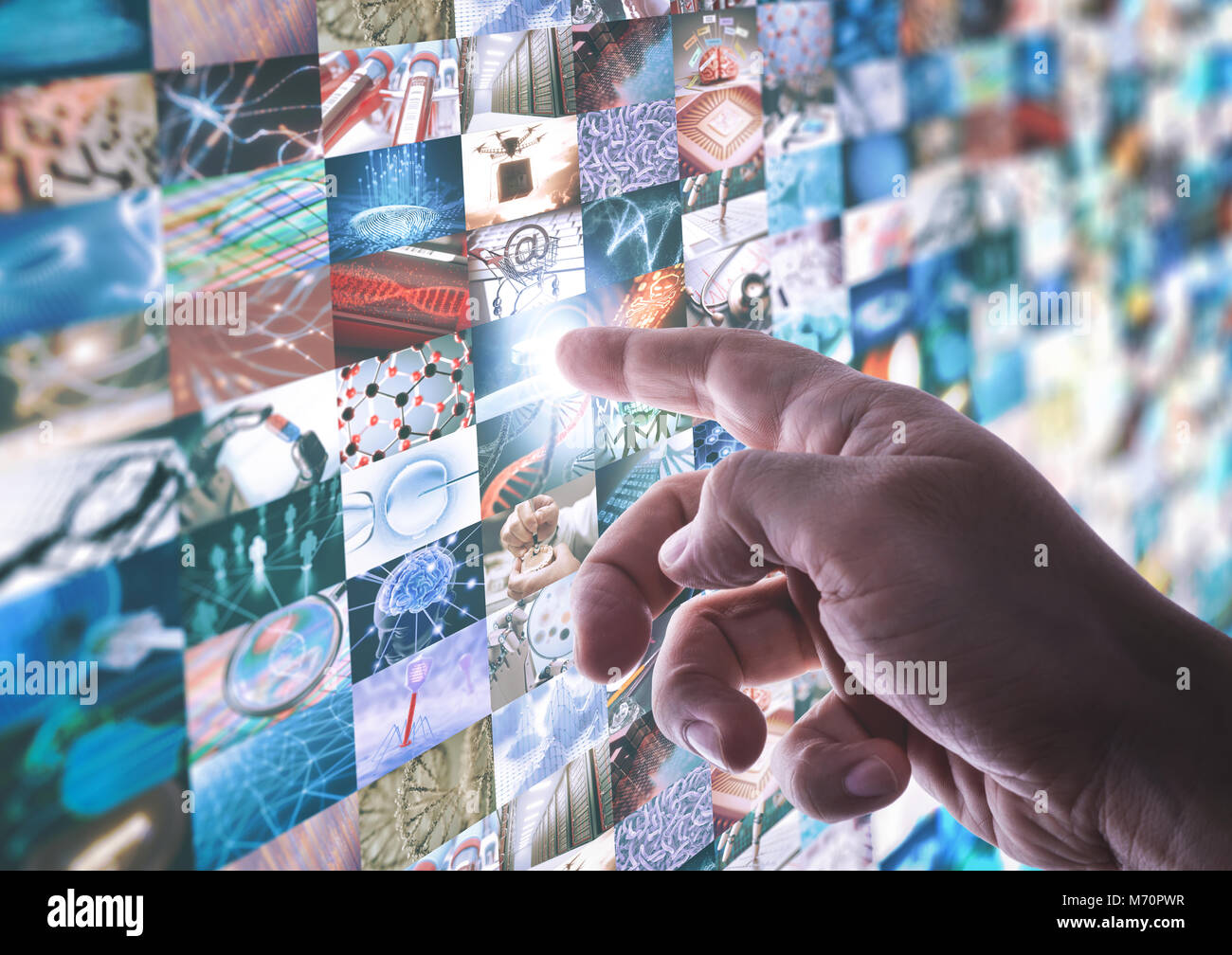 La main touche l'écran tactile du panneau led avec différentes images à propos de la technologie et de la science. Banque D'Images