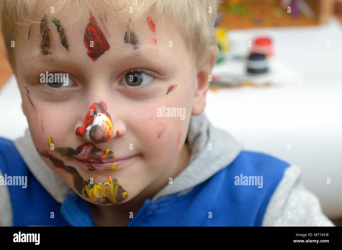 Le visage de l'enfant, de traces de peinture, de rires drôle et joyeusement Banque D'Images