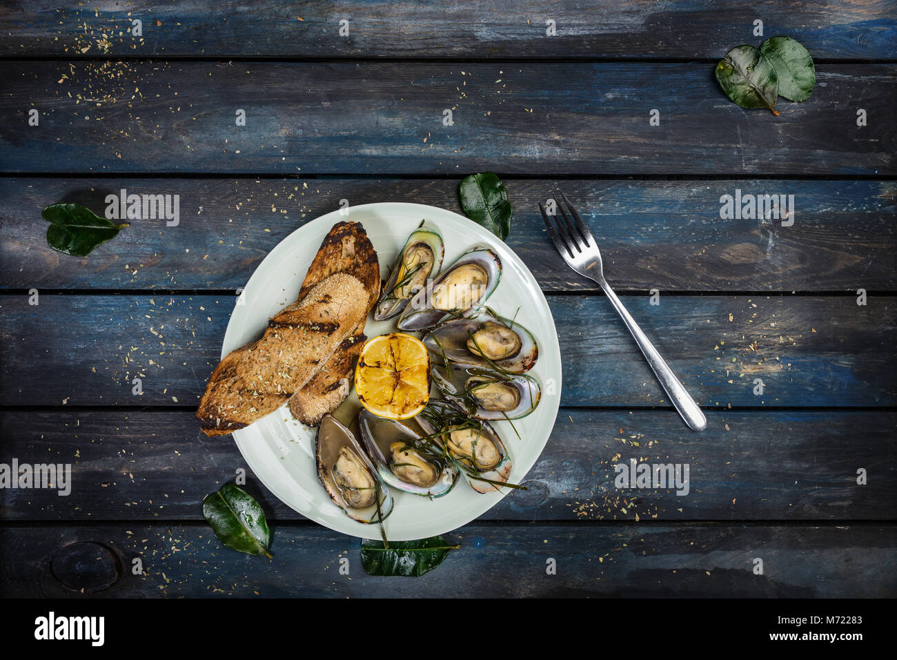 Les moules et toasts de pain sur sur une plaque blanche. Vue d'en haut Banque D'Images