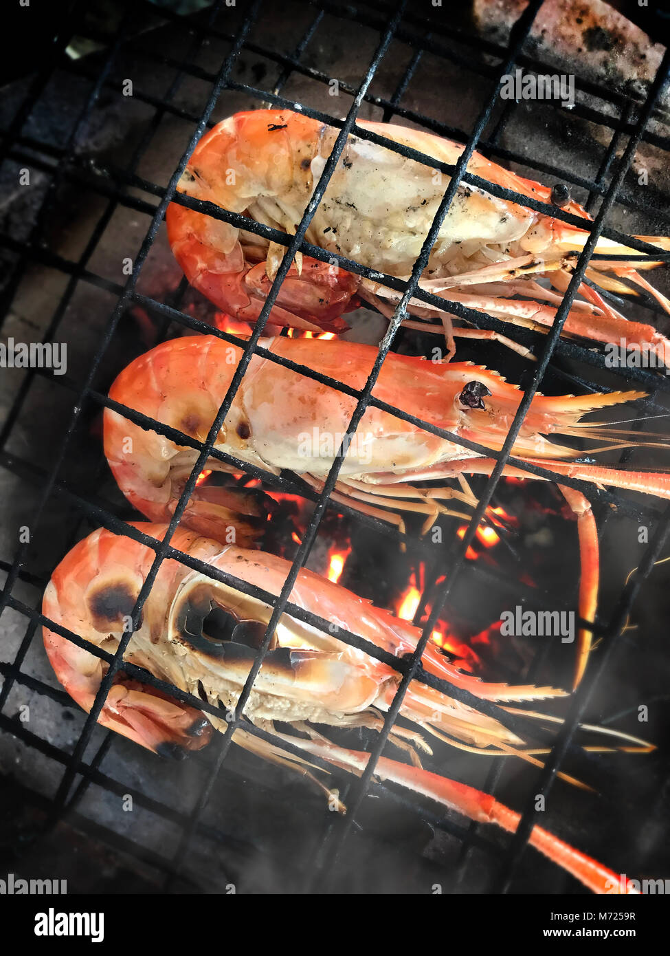 La cuisson des crevettes avec du charbon de bois chaud rivière flaming photo avec un faible éclairage intérieur. Banque D'Images