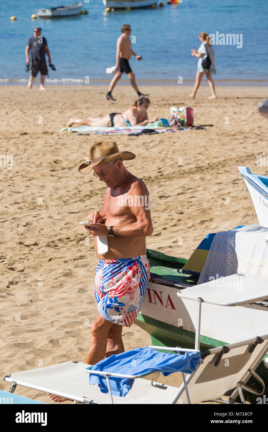 Man using mobile phone on beach Banque D'Images