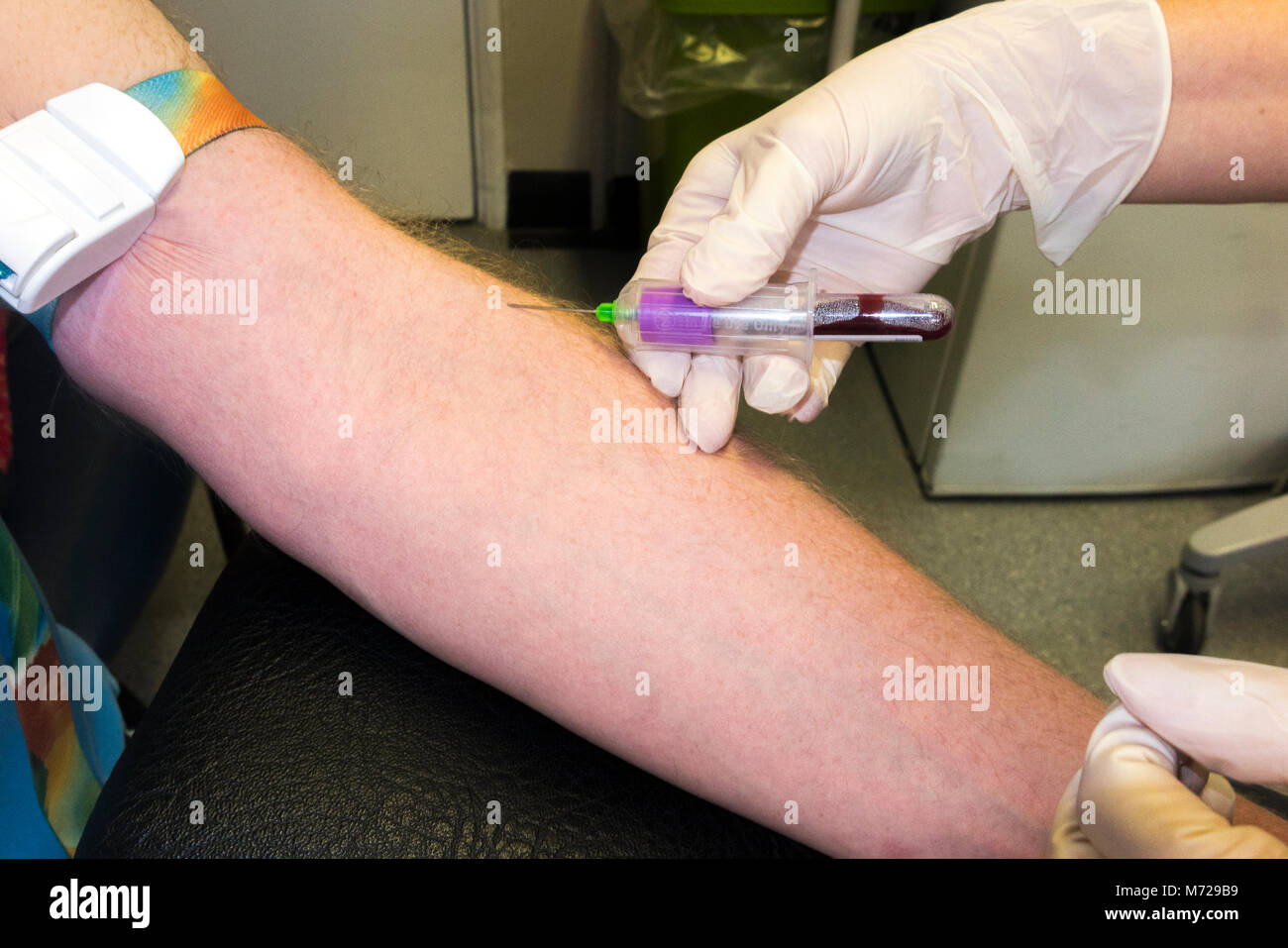 Test sanguin effectué sur le bras d'un homme d'âge moyen / sang prélevé pour examen par une infirmière de pratique à un médecin / médecin chirurgie. ROYAUME-UNI (95) Banque D'Images