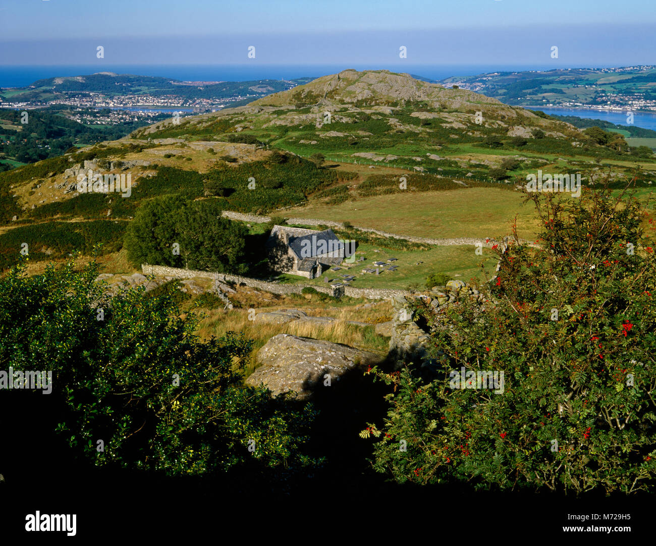 La vieille église St Celynin : voir l'ENE à Cerrig y Ddinas rocheux, Conwy Llandudno et au-delà. Gelynin Ffynnon puits sacré en S corner (près de R) de cimetière. Banque D'Images