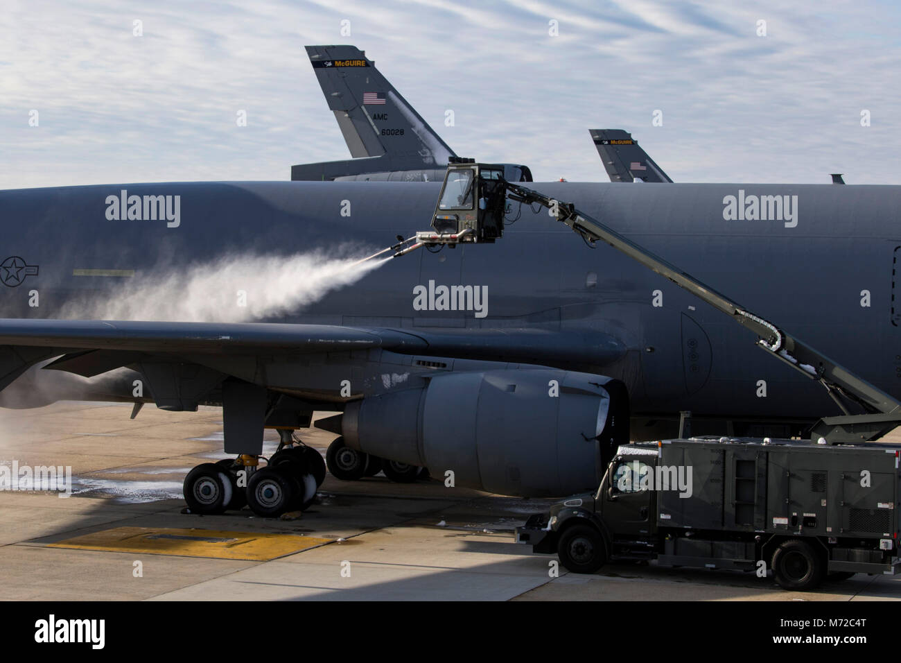 Les aviateurs de l'US Air Force avec le 305e Escadron de maintenance des aéronefs spray liquide de dégivrage sur l'aile d'un KC-10 Extender at Joint Base McGuire-Dix-Lakehurst, N.J., le 3 mars 2018. (U.S. Air Force photo par le Sgt. Mark C. Olsen) Banque D'Images