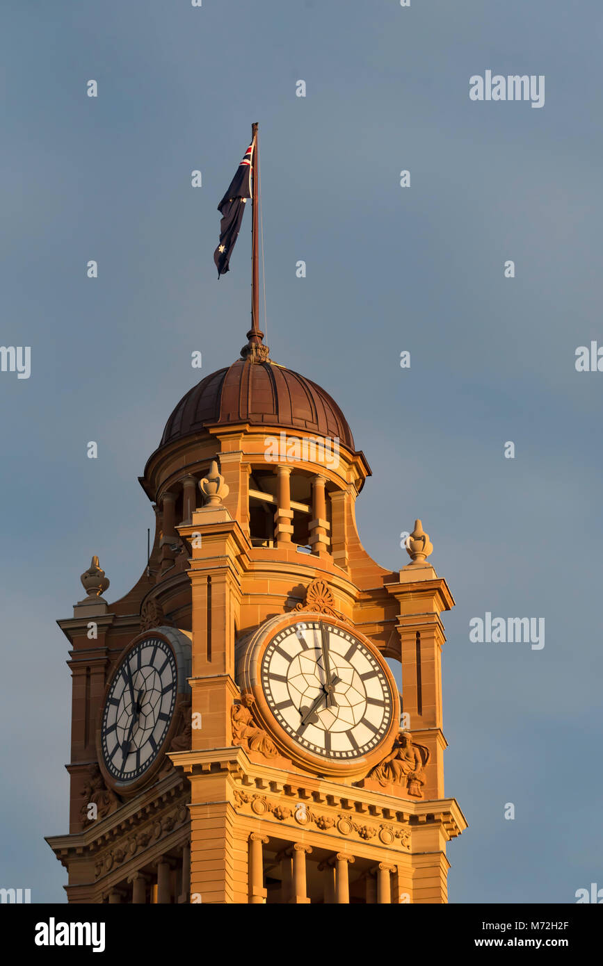 La tour de l'horloge avec son dôme en bronze et drapeau australien au sommet baigne dans le soleil du matin à l'emblématique Sydney Central Station, NSW, Australie Banque D'Images