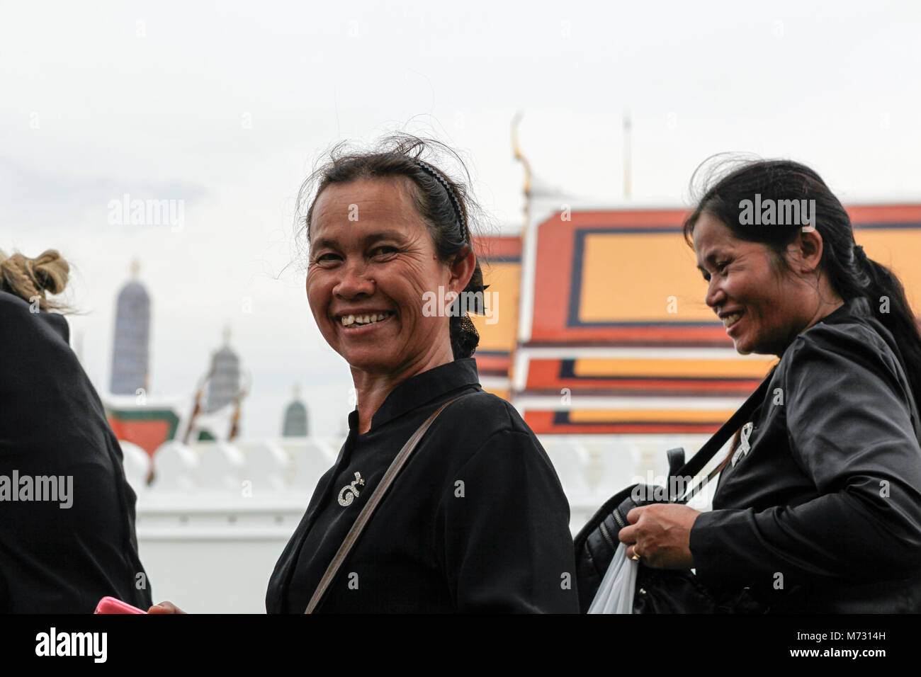 Deux femmes sourire à l'appareil photo autour du Grand Palais, pendant le deuil pour la fin roi Thai Banque D'Images