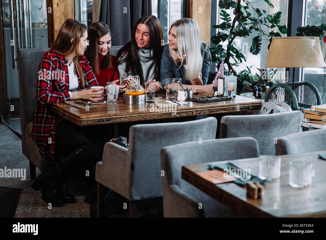 Quatre amis féminins bénéficiant d'en parler au café Banque D'Images