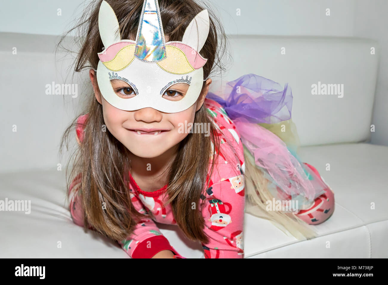 Une fillette de six ans portant un masque de licorne Banque D'Images Une fillette de six ans portant un masque de licorne Banque D'Images