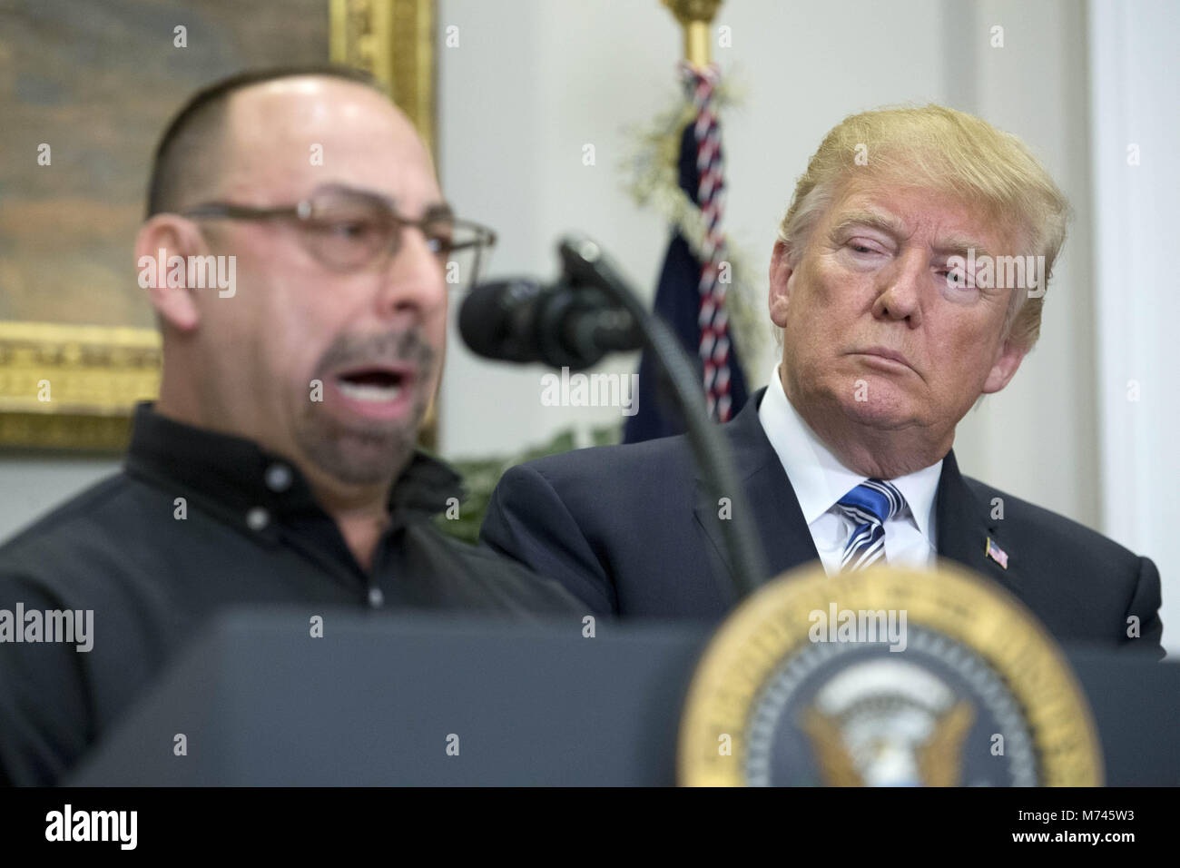 8 mars 2018 - Washington, District de Columbia, États-Unis d'Amérique - Le président américain, Donald J. Trump (R) est à l'écoute de Scott Sauritch (L), ouvrier d'entretien à Irvin Works et président du syndicat local 2227 ; avant de signer une déclaration présidentielle sur l'acier et l'aluminium dans les tarifs douaniers, Roosevelt Room de la Maison Blanche à Washington, DC, USA, 08 mars 2018. Le président Trump est l'imposition de droits de douane sur les importations d'acier et d'aluminium. La décision d'imposer des tarifs douaniers sur le Canada ou le Mexique ne sera pas décidé jusqu'à ce que les négociations sur l'Accord de libre-échange nord-américain (ALENA).Crédit : Michael Reynolds Banque D'Images