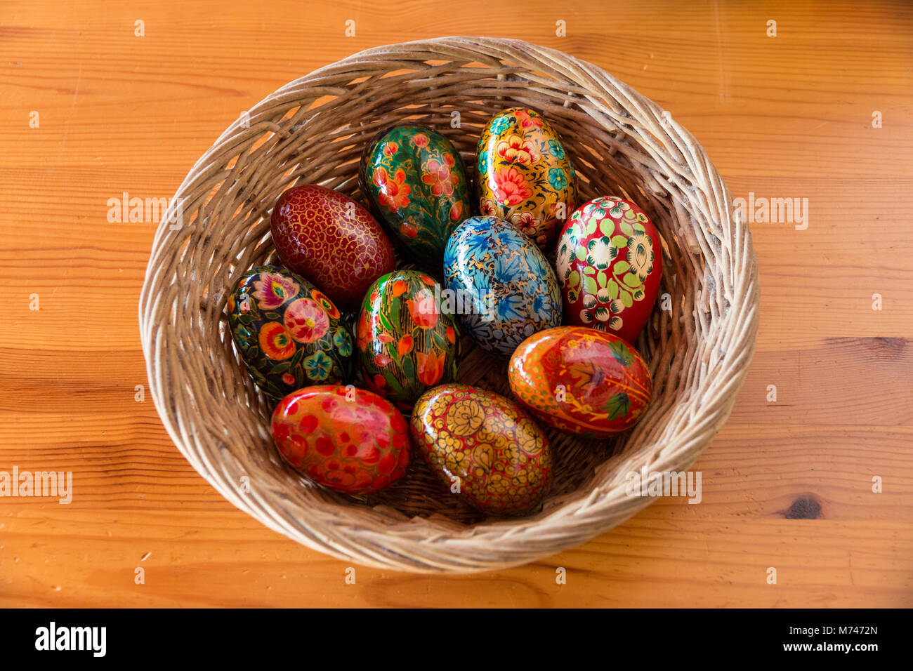 Un panier avec des oeufs en bois peint magnifiquement comme décoration de Pâques. Banque D'Images