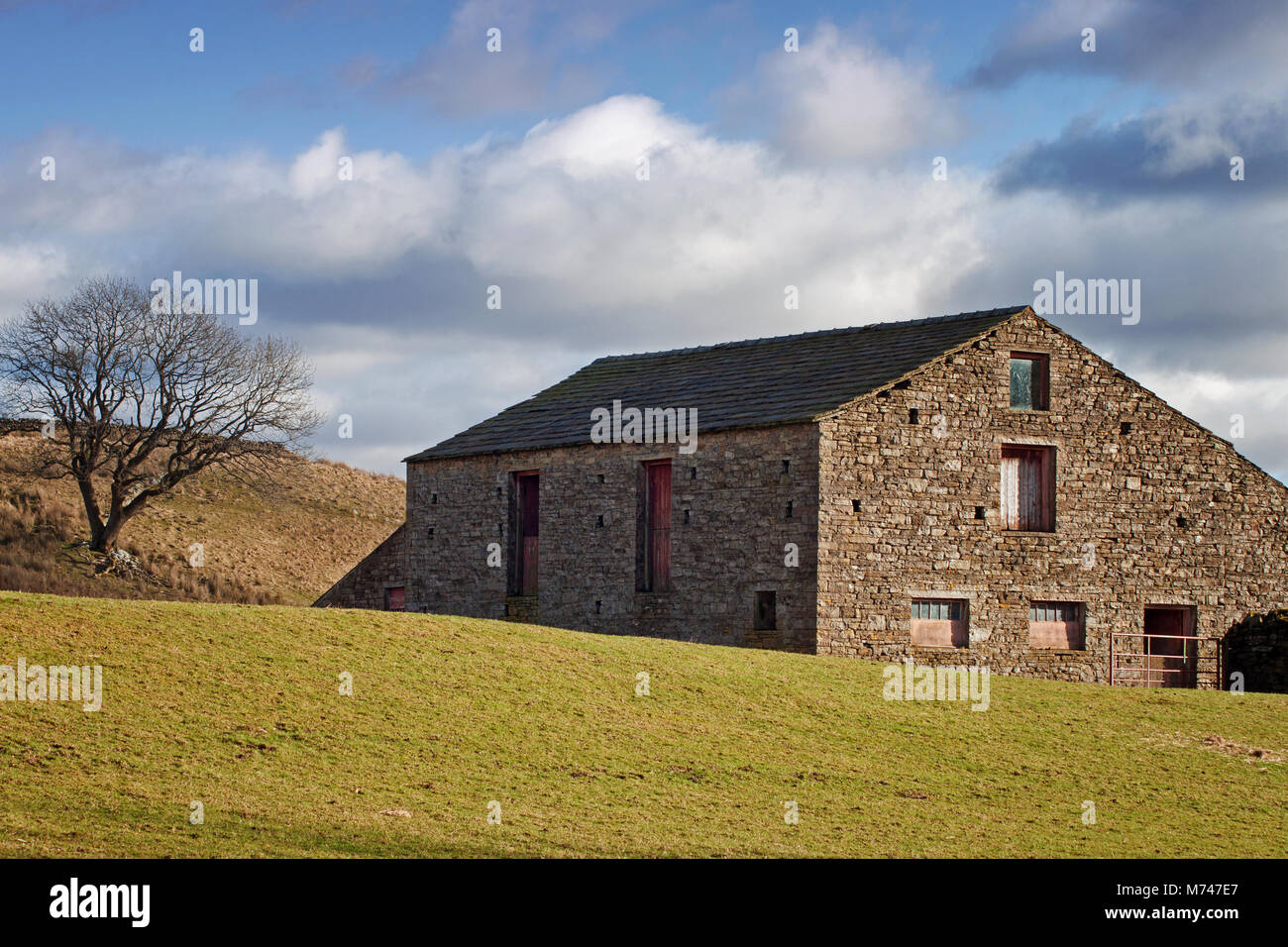 Ombres projetées par le soleil d'hiver tombant sur une ferme à Cotterdale désolées Beck, UK Banque D'Images