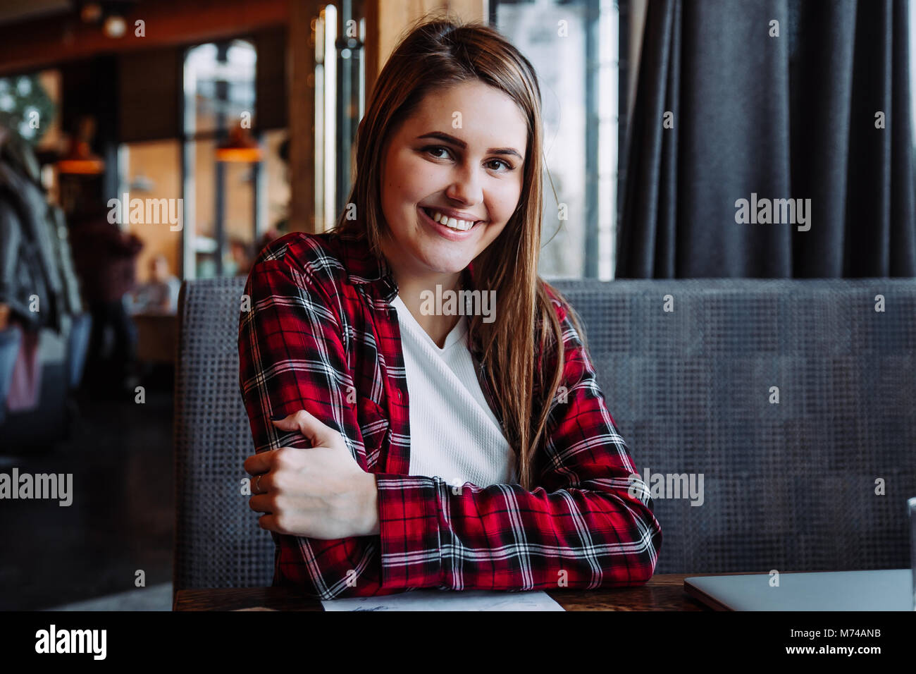Belle brunette smiling at camera sitting in cafe Banque D'Images