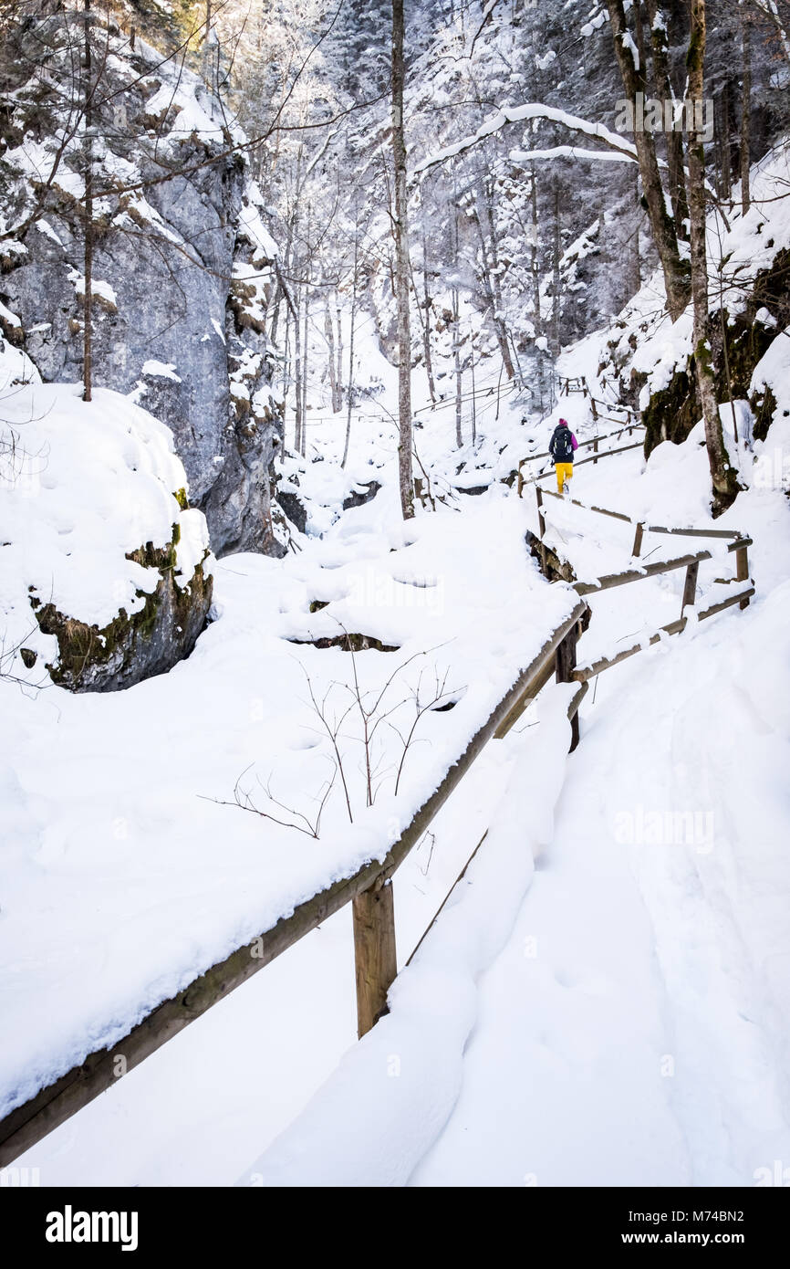 Les jeunes femmes randonner Échelles de bois et des ponts couverts de neige par Baerenschuetzklamm avec gorge glacée congelés cascades Banque D'Images